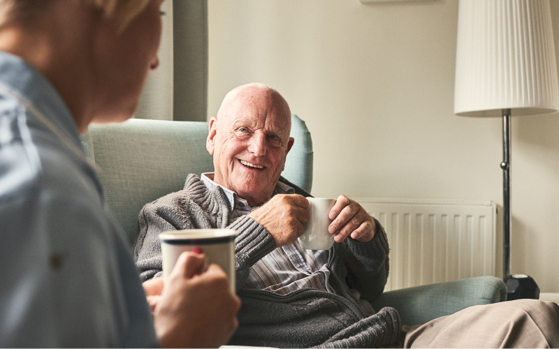 Elderly person having a hot drink.