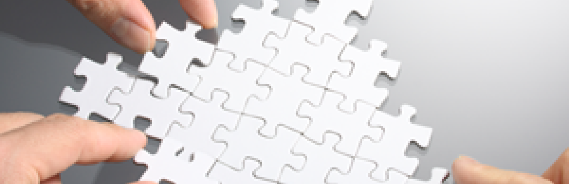 hands putting together puzzle pieces