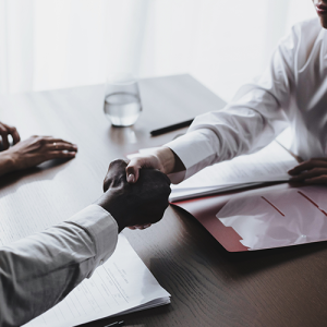 people sitting by a table shaking hands