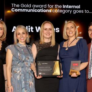 Five people on stage with award